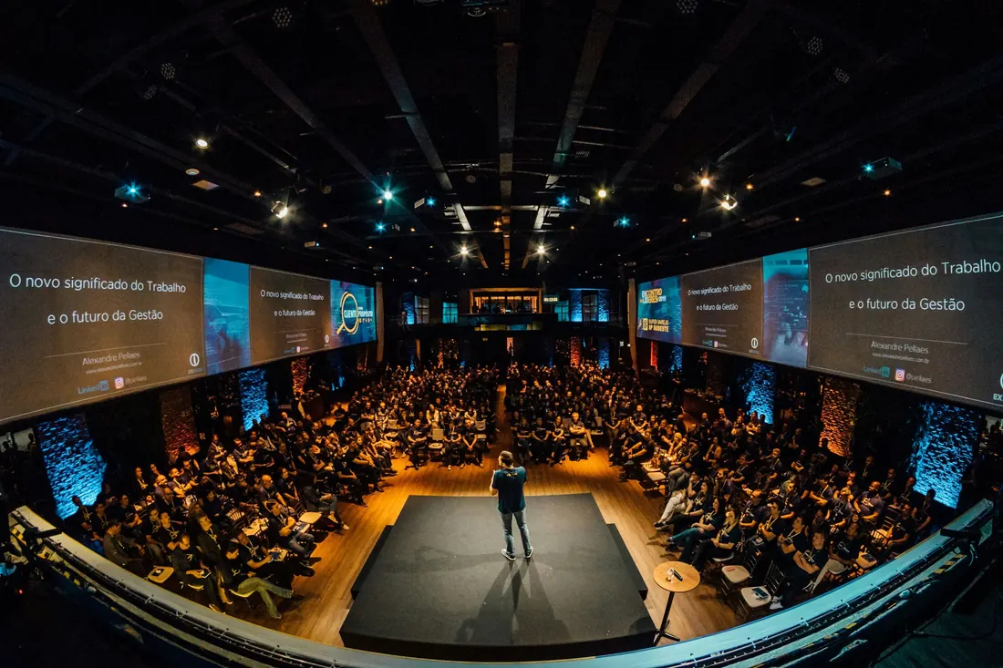 A keynote speaker on stage in front of a large audience